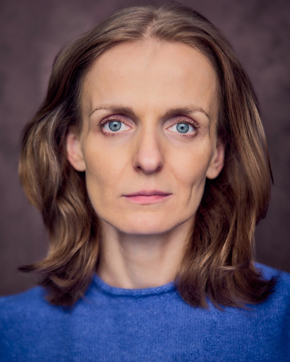 Monika Valkunaite headshot, blue jumper